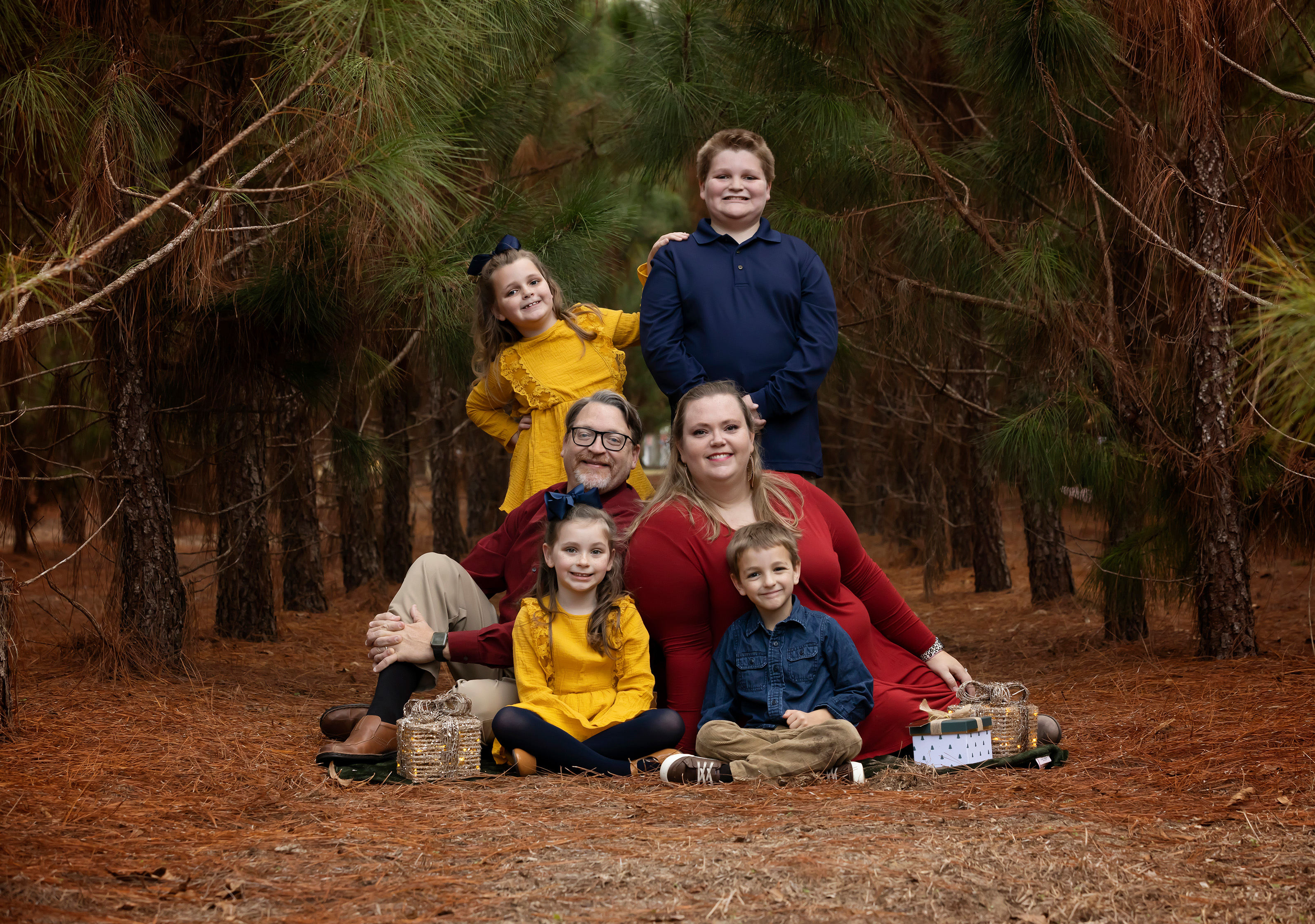 Family standing amongst pine trees