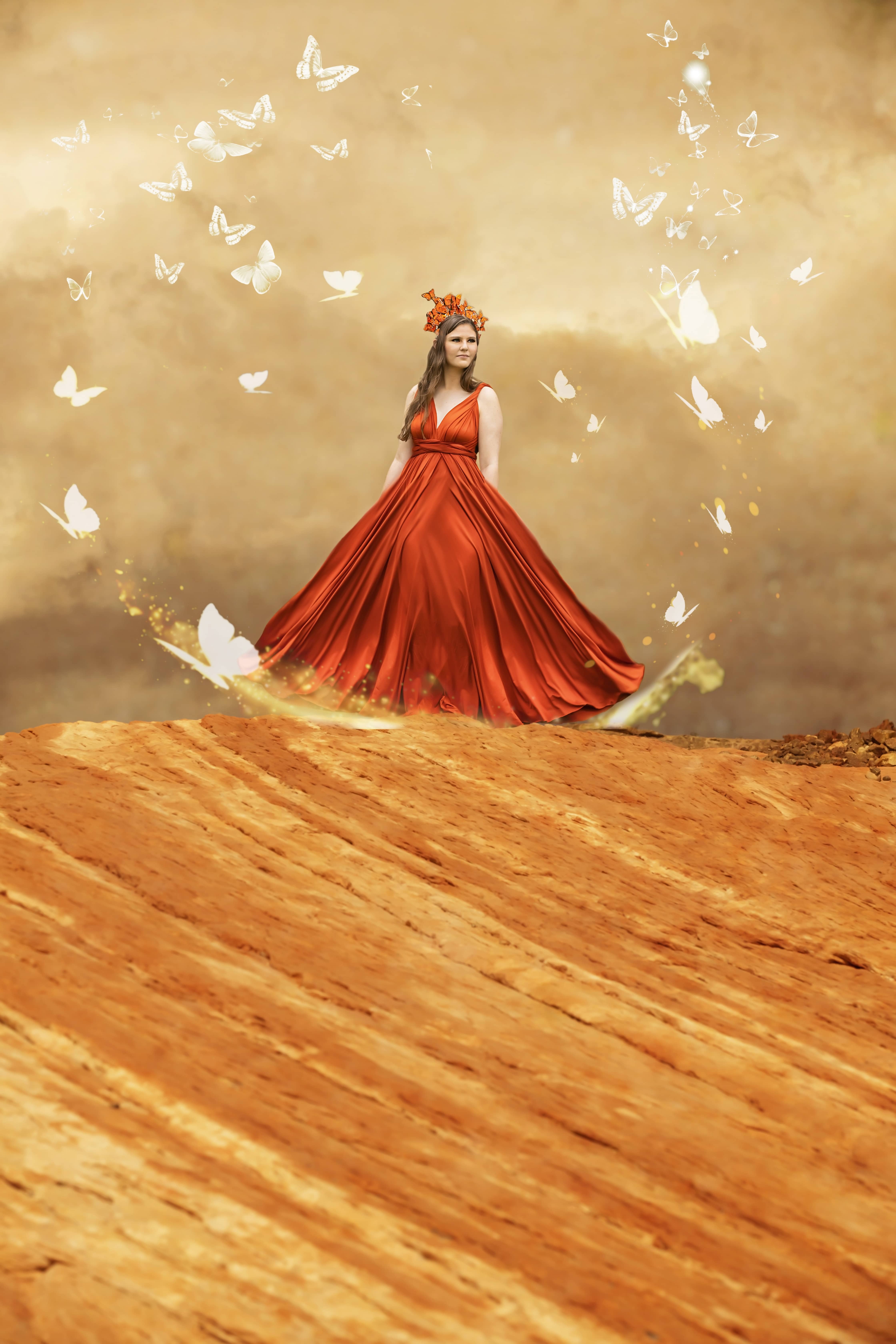 Woman stands on top of a sand dune