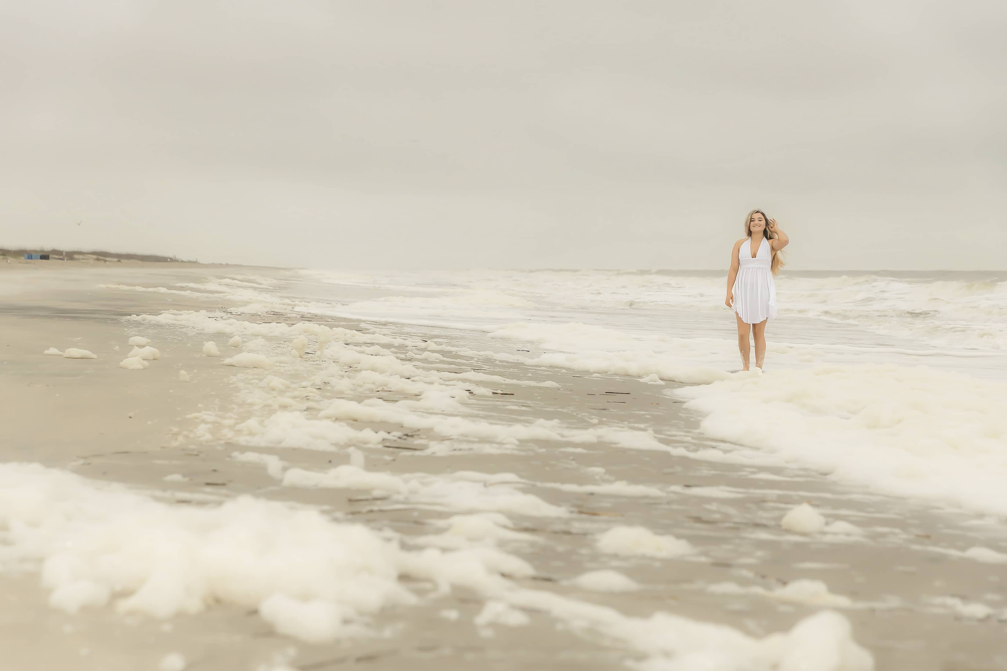 Woman stands in the tide at the beach