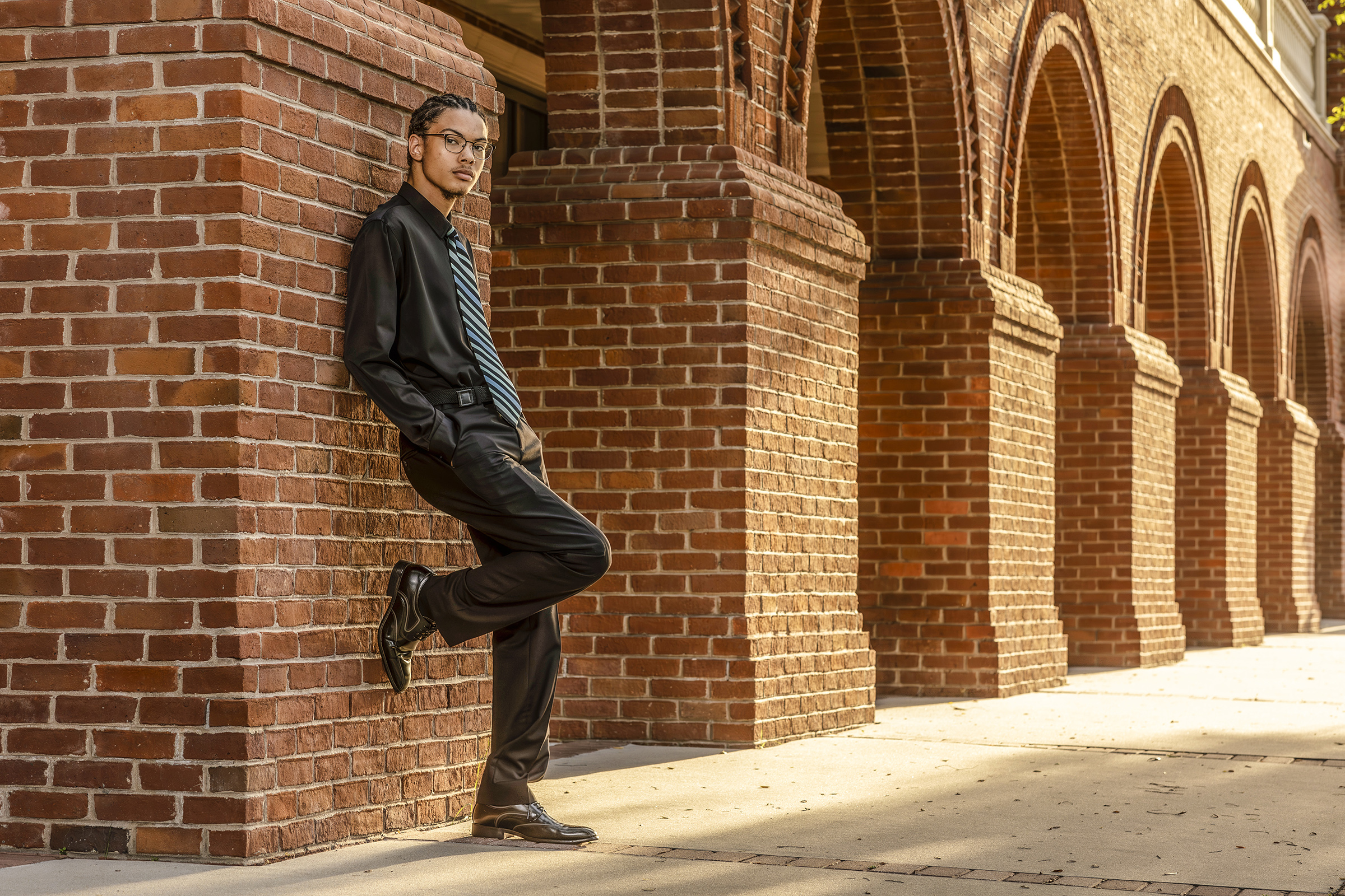 Man leans against brick wall